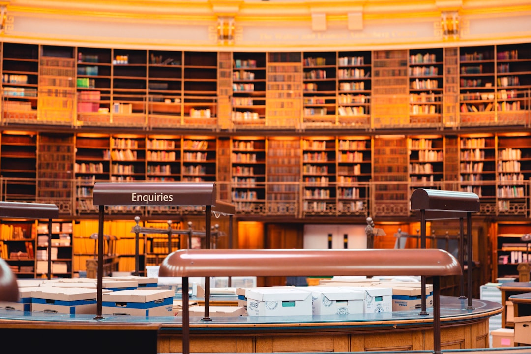 A grand library filled with books and tables.